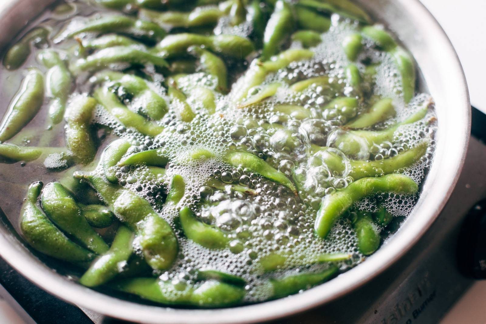 Boiling edamame in a pot of water.