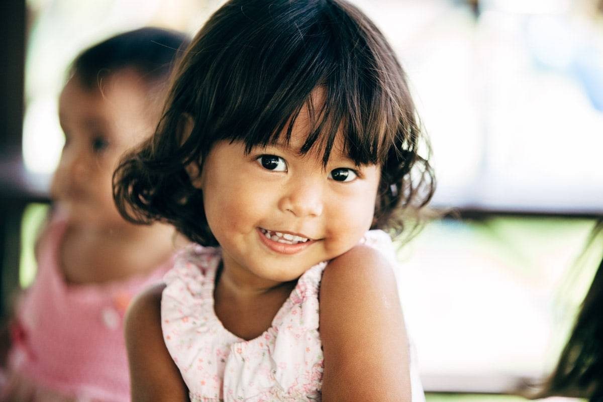 Little girl smiling at camera.