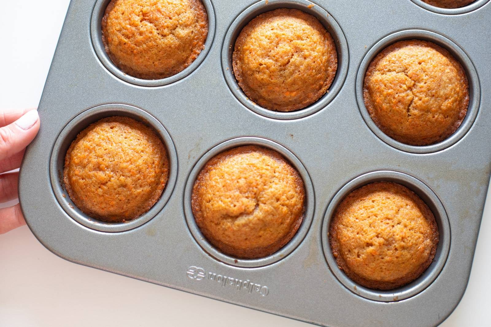 Carrot cake cupcakes baked in a muffin tin.