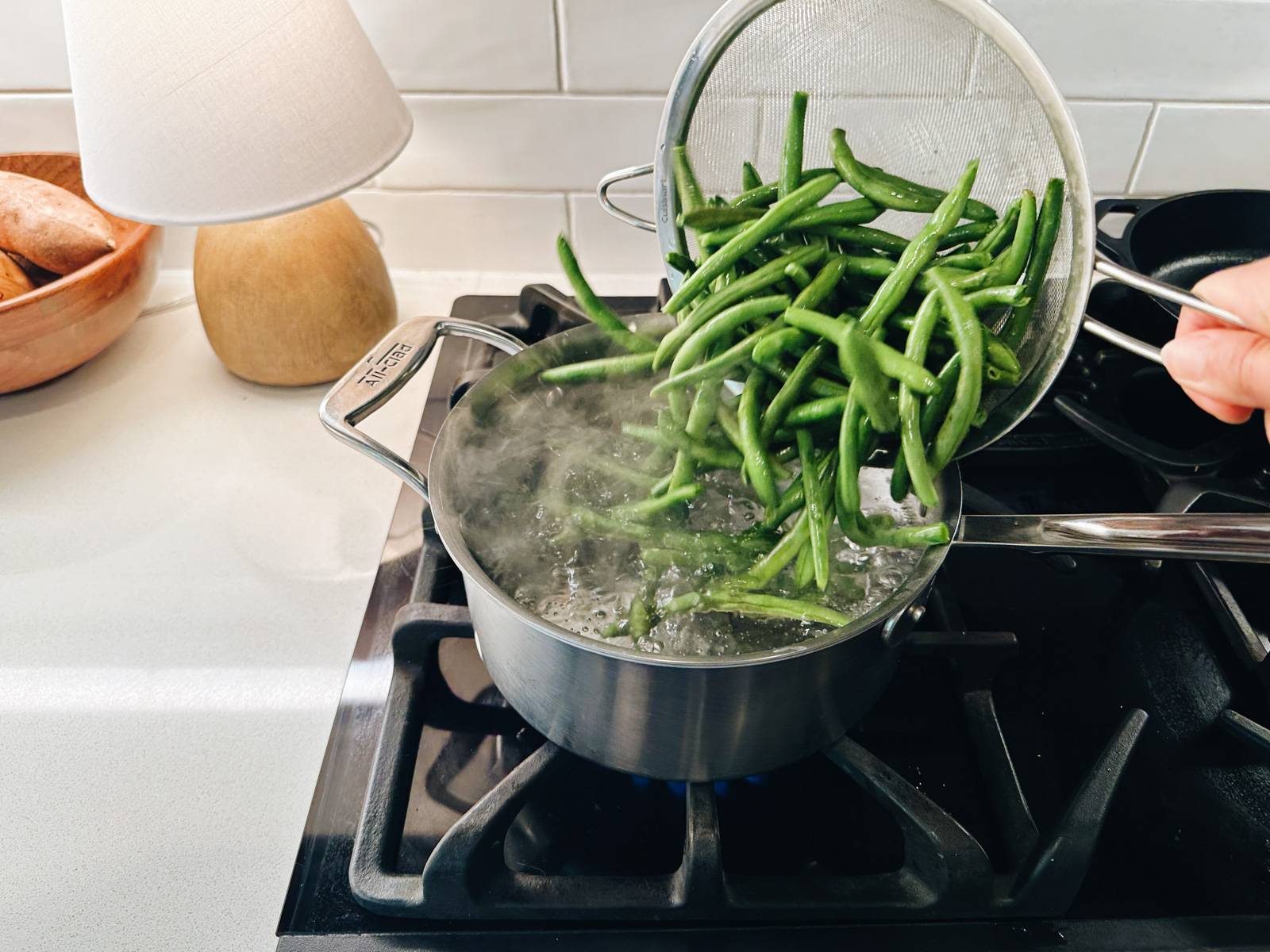 Blanching green beans in a pot.