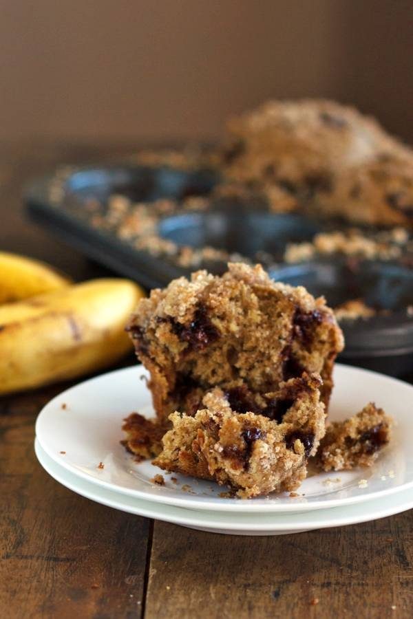Chocolate chip banana peanut butter muffin in pieces on a plate.