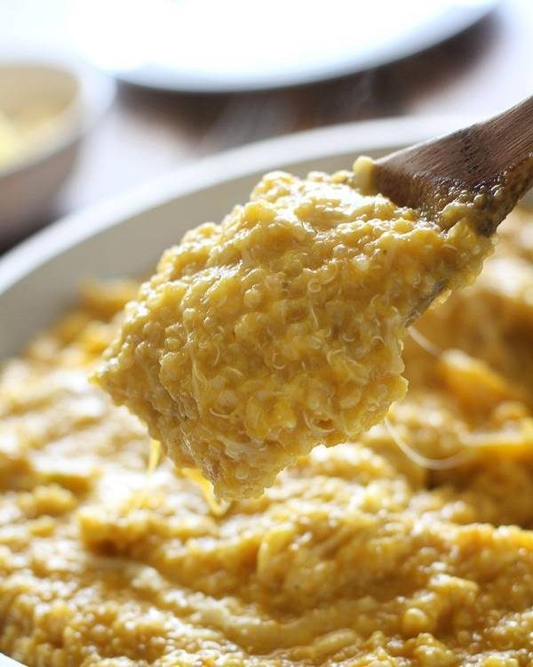 Squash curry quinoa in a bowl and on a wooden spoon.