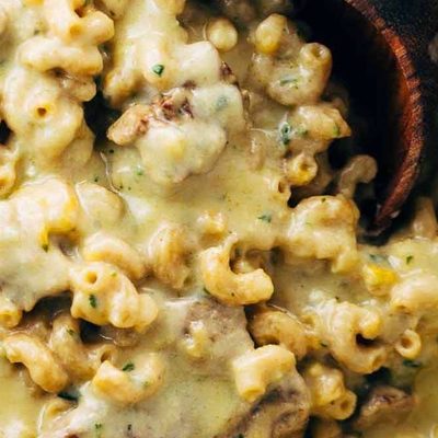 Steak and Cheddar Mac and Cheese in a pot with a spoon.