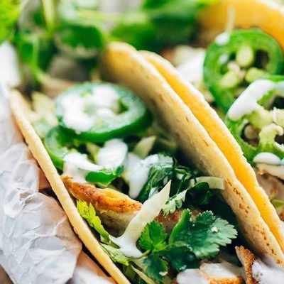 Ancho Chicken Tacos in basket with limes.