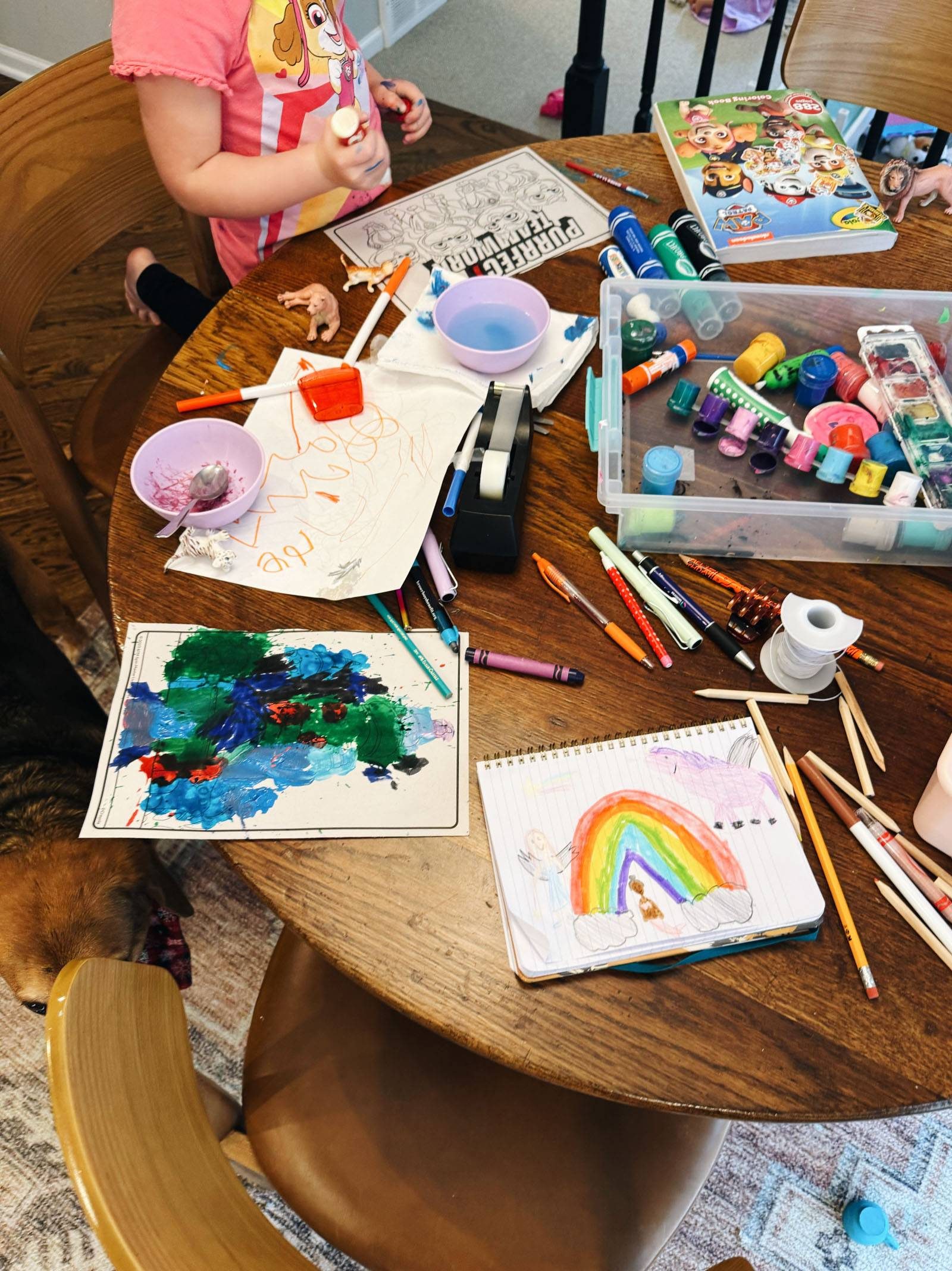 Coloring and painting activities on a wood table.