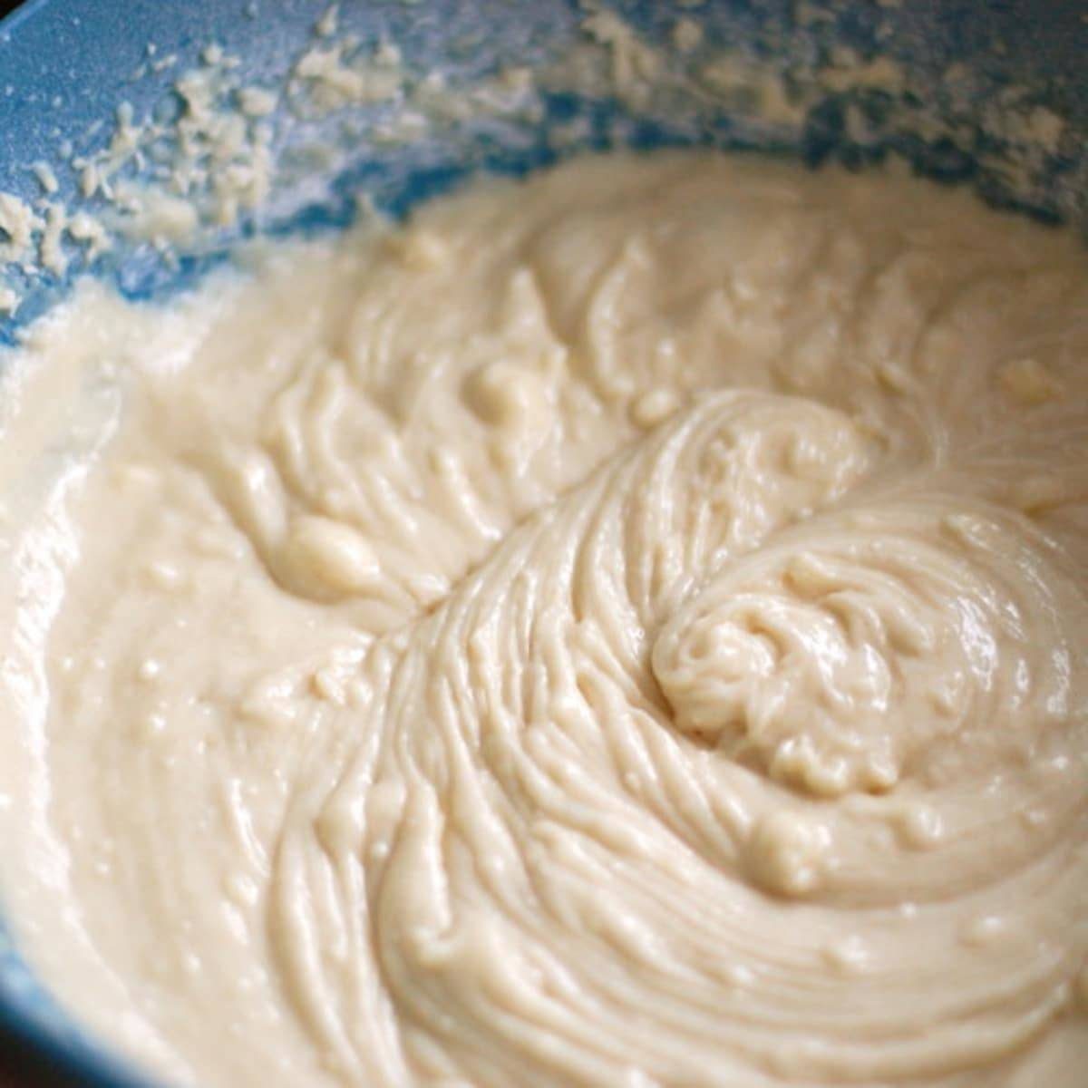 Coffee streusel bundt cake dough in a blue bowl.