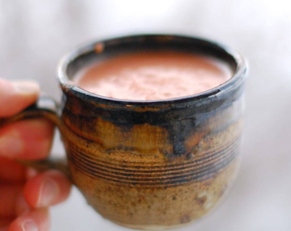 Creamy tomato balsamic soup in a clay mug.