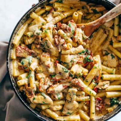 Sun Dried Tomato Chicken Florentine Pasta in a pan with a spoon.
