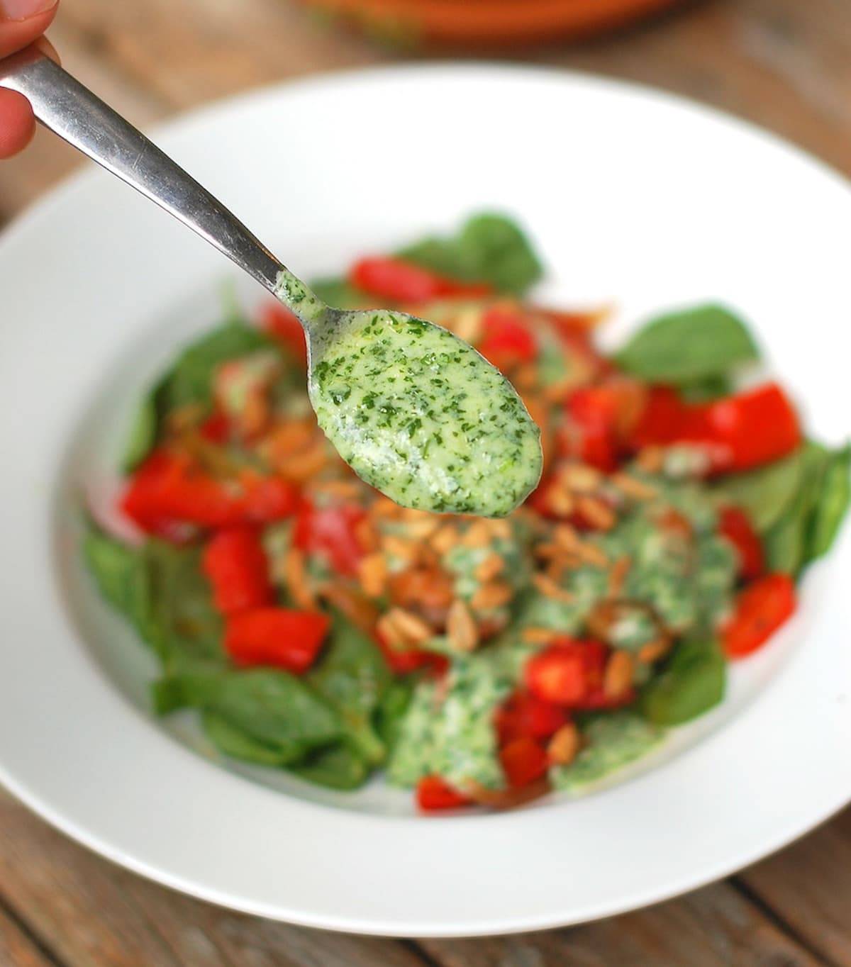 Creamy cilantro dressing on a salad and on a spoon.