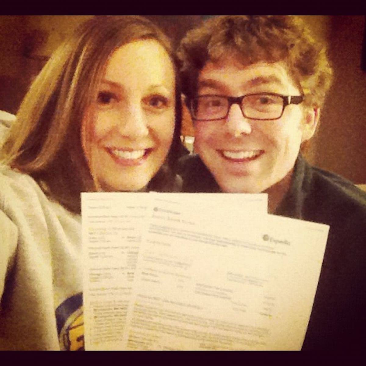 Two people holding plane tickets.